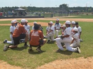 Baseball U Long Island team gathered with coach on the field